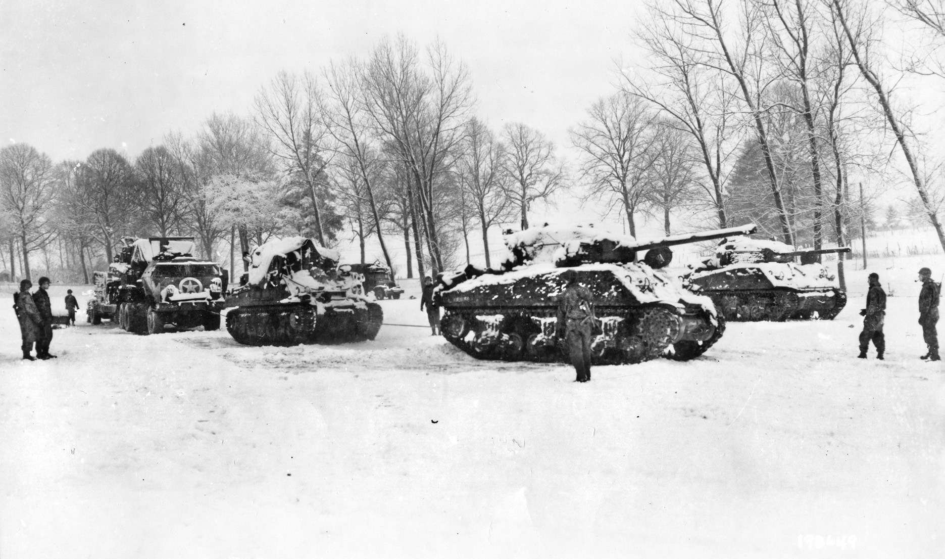 9th Armored Division troops prepare to recover tanks disabled during fighting in the Bulge.