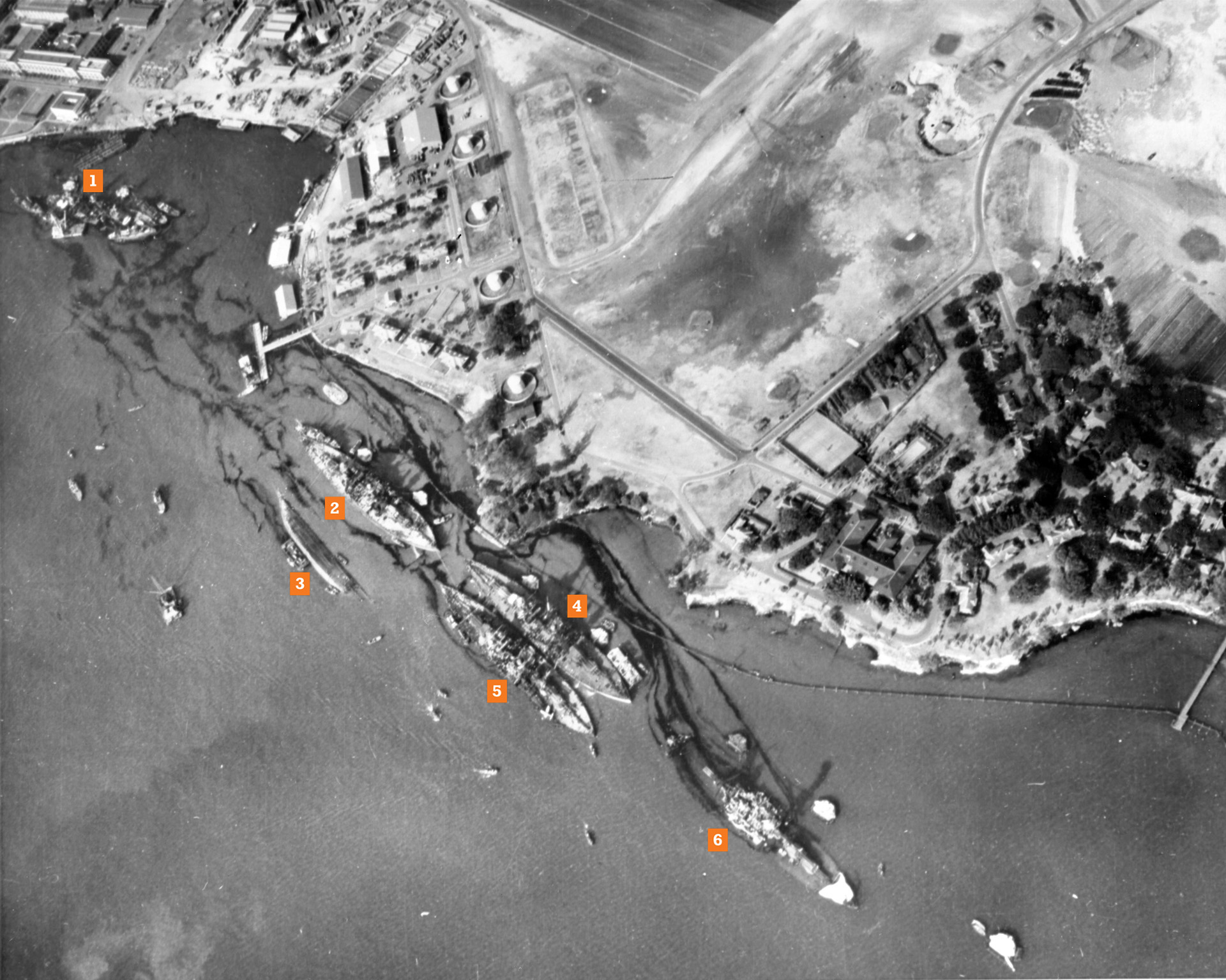 This aerial view of Battleship Row and Ford Island was taken three days after the attack, and the heavy damage sustained during the Japanese attack is readily apparent.