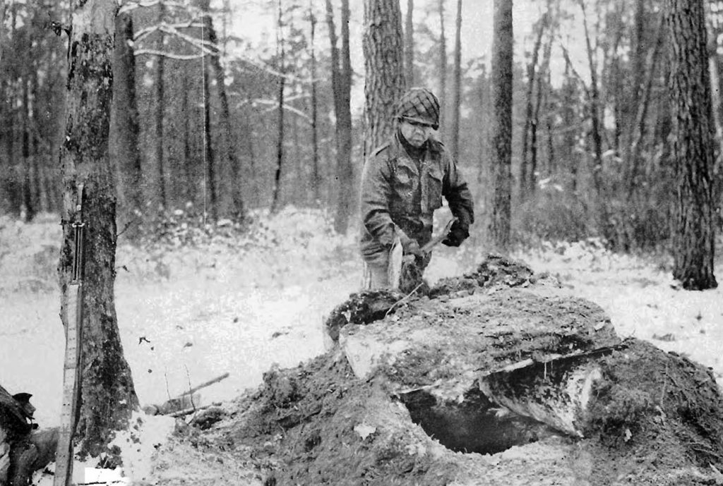 Reinforcing the roof of his foxhole and waiting for a German attack, a soldier of the U.S. 42nd Infantry Division maintains his position near the town of Hatten, where a German attack was expected. 