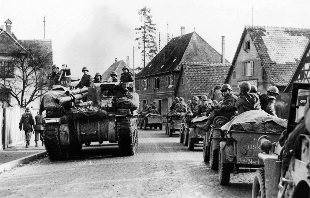 Elements of the 79th Infantry Division move through the French village of Wissonburg on December 15, 1944, the eve of the Battle of the Bulge. Ravaged during the fighting in the Ardennes, the 79th Division joined elements of the 42nd Infantry Division in the town of Hatten by January. 