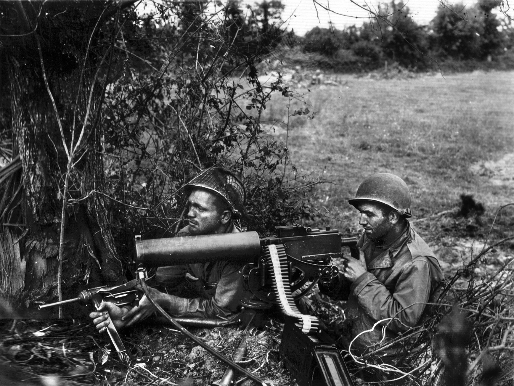 Two American soldiers man their position in Normandy in this photo from June 1944. One soldier is ready for action with a Browning .30-caliber machine gun, while the other is armed with an M3. 