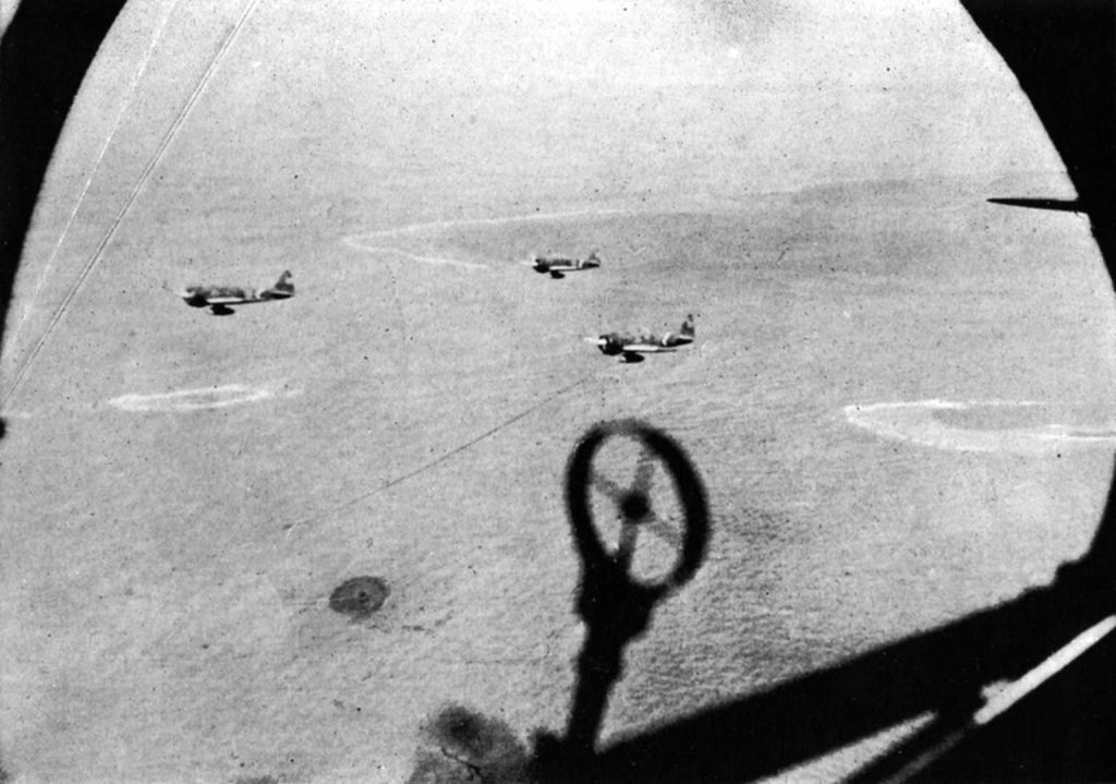 In this photograph, taken from the window of a Japanese bomber, Zero fighters escort a formation during a raid against American forces in the Solomon Islands.