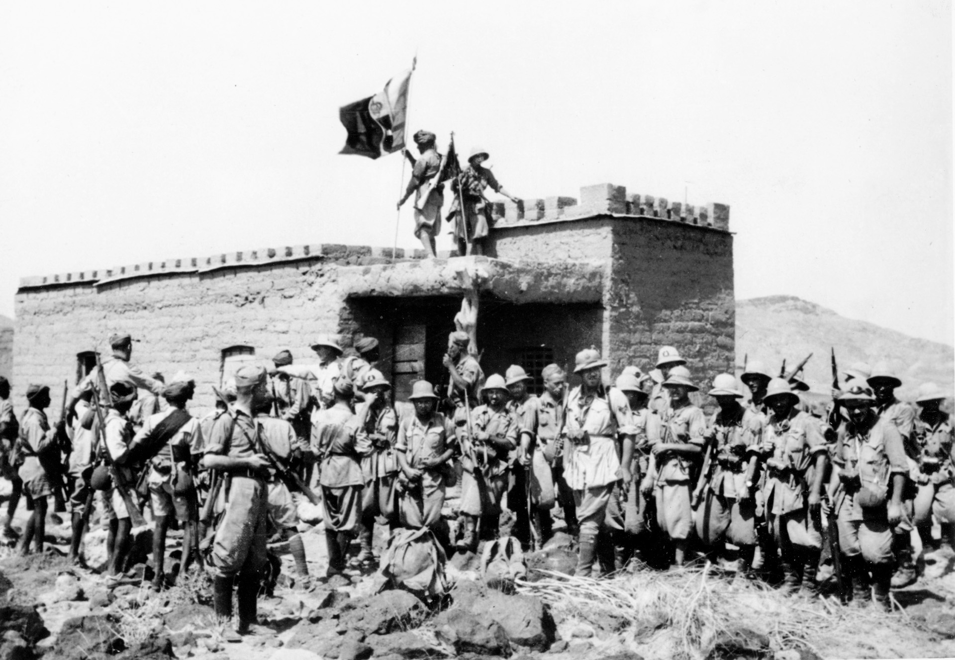 Raising their banner atop a captured British fortification at Jirreh in British Somaliland, Italian soldiers celebrate their victory on August 22, 1940. British offensive operations launched in late 1940 ejected the Italians from their gains in British Somaliland.