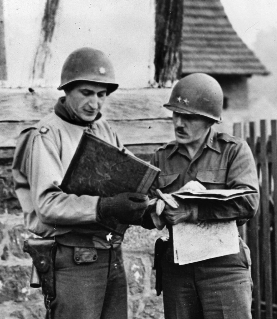 Conferring with Lieutenant Colonel Everett Duval, Major General Robert Frederick (right) commanded the 45th Infantry Division.