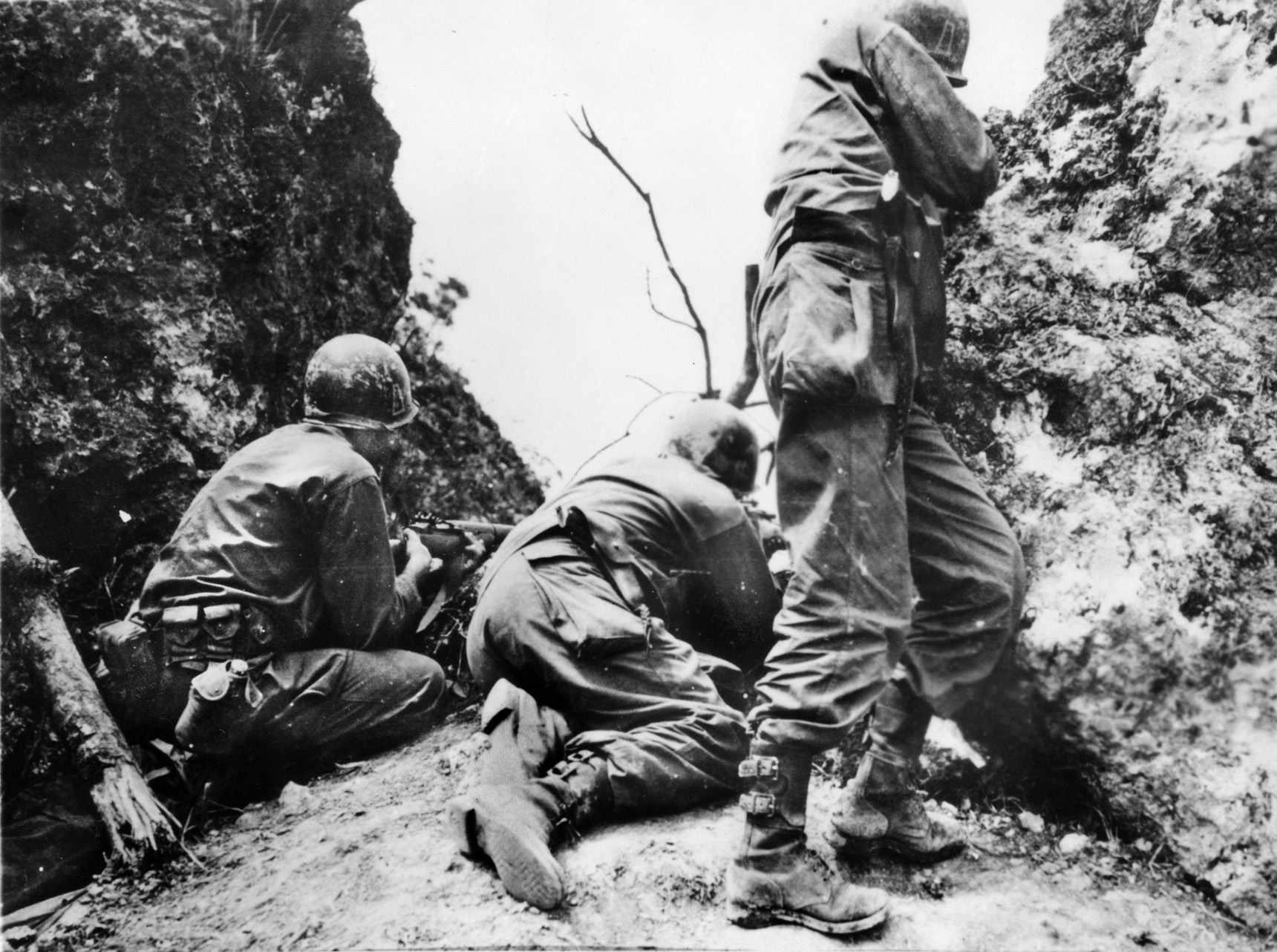 Taking cover behind a coral outcropping, soldiers of the U.S. 96th Division fire at the Japanese on Okinawa. 