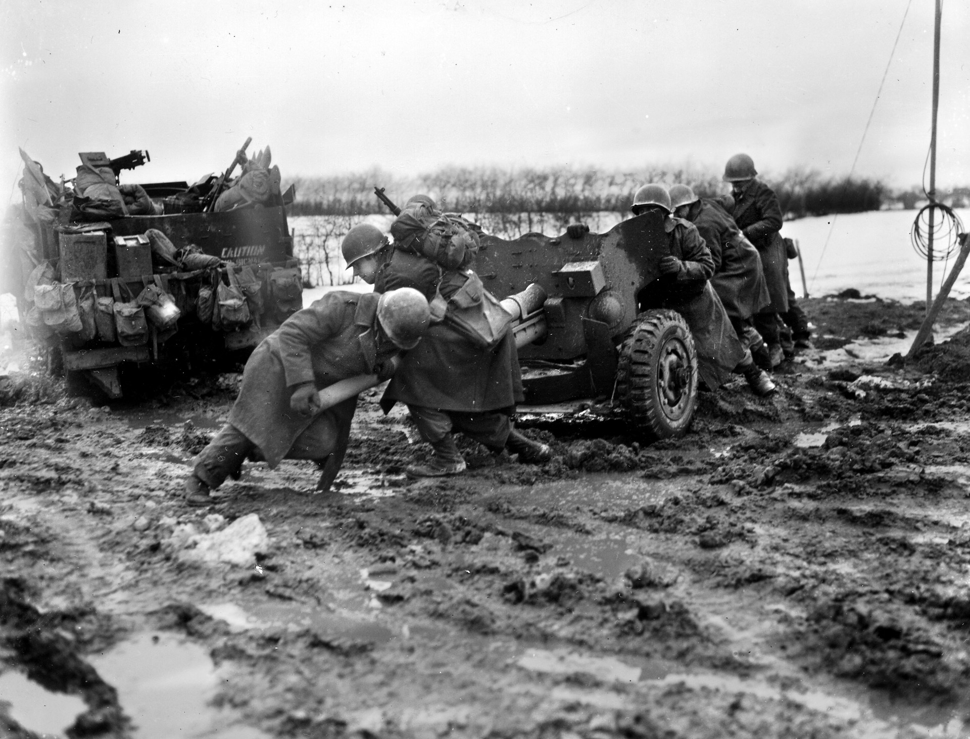 GIs manhandle a 57mm anti-tank guns into position during the Battle of the Bulge.