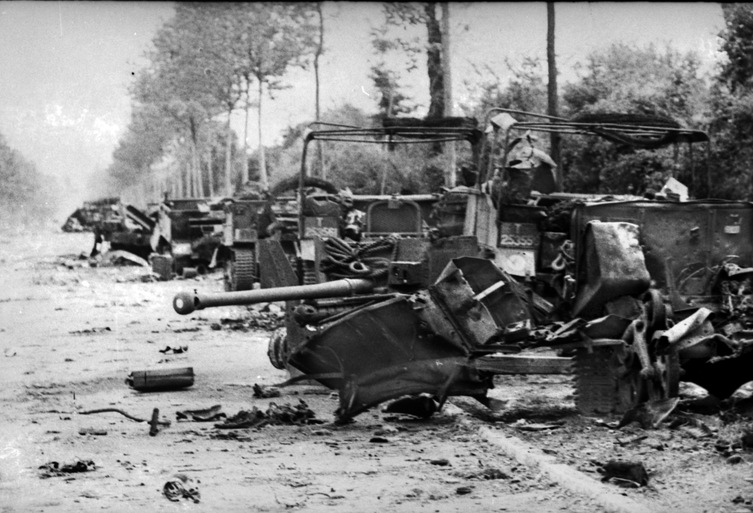 A column of British armored vehicles smolders in ruin after being blasted by Oberstürmführer Michael Wittmann's Tiger I tank. 