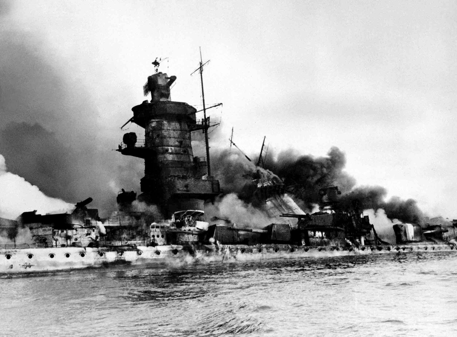 Scuttled by its crew, the pocket battleship Graf Spee lists heavily and settles during its death throes on December 17, 1939, off the mouth of the River Plate and the harbor of Montevideo, Uruguay. After a battle with three British cruisers, Captain Hans Langsdorff was convinced that an overwhelming Allied naval force awaited his return to sea from Montevideo and ordered his crew to sink their own ship.