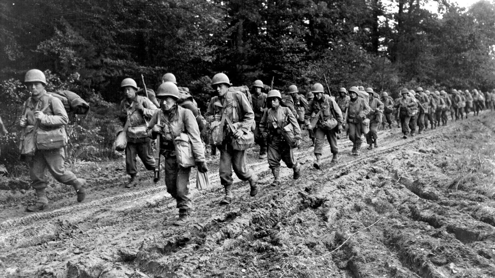 Slogging their way along a road in the Chambois sector of the Vosges Mountains in October 1944, soldiers of the Japanese-American 442nd Regimental Combat Team advance toward the front lines during their heroic effort to rescue the Lost Battalion of the 36th Infantry Division. 