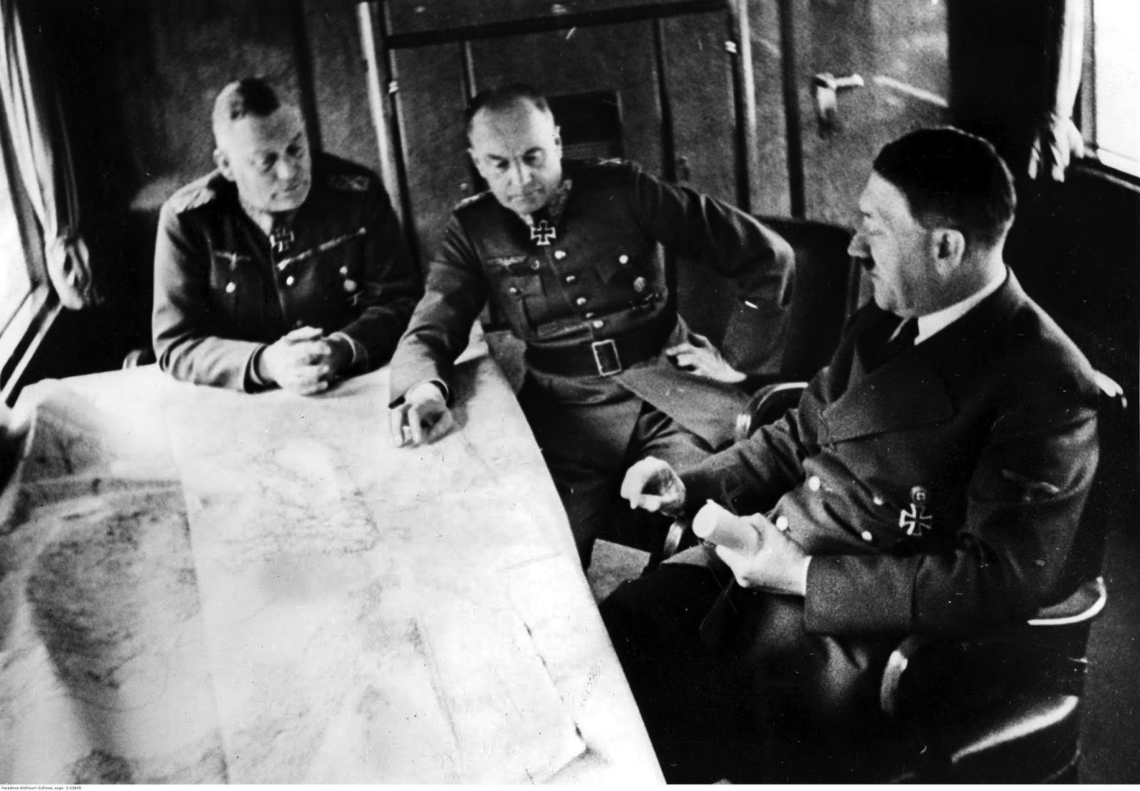 Hitler confers with his subordinates Field Marshal Wilhelm Keitel (left) and Field Marshal Walter von Brauchitsch (center) as the three contemplate a military map on the table before them. As Operation Barbarossa progressed, Hitler sacked Brauchitsch and took personal command of all German forces on the Eastern Front. TOP: The burned-out hulks of Soviet T-26 light tanks destroyed during early fighting against the invading Nazis lie derelict on the battlefield.