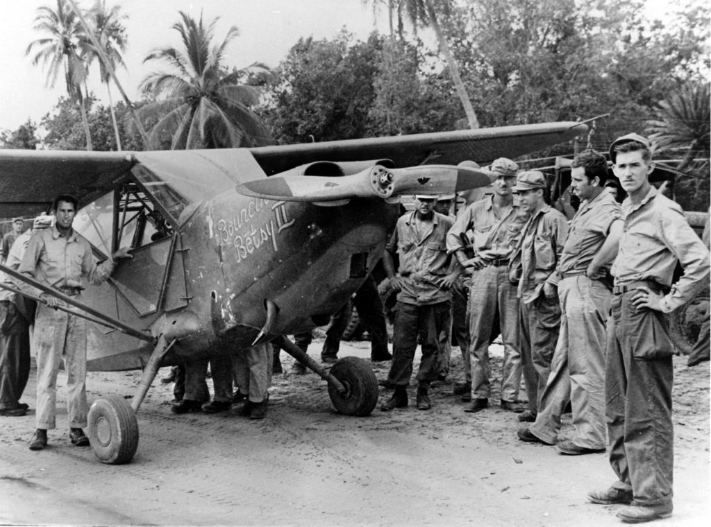 Sergeant pilots of the 25th Liaison Squadron gather around an L-5 Sentinel aircraft. They performed rescue missions in New Guinea, extracting downed pilots, and scouted enemy positions, which were often concealed beneath the jungle canopy. When Japanese positions were located, they regularly led fighters to these targets for strafing runs. 