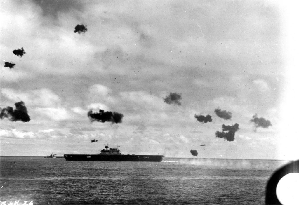 Two Japanese Nakajimma B5N “Kate” torpedo bombers fly past the aircraft carrier USS Yorktown after releasing torpedoes during an attack at mid-afternoon on June 4. These Kates had taken off from the deck of the carrier Hiryu earlier that day.