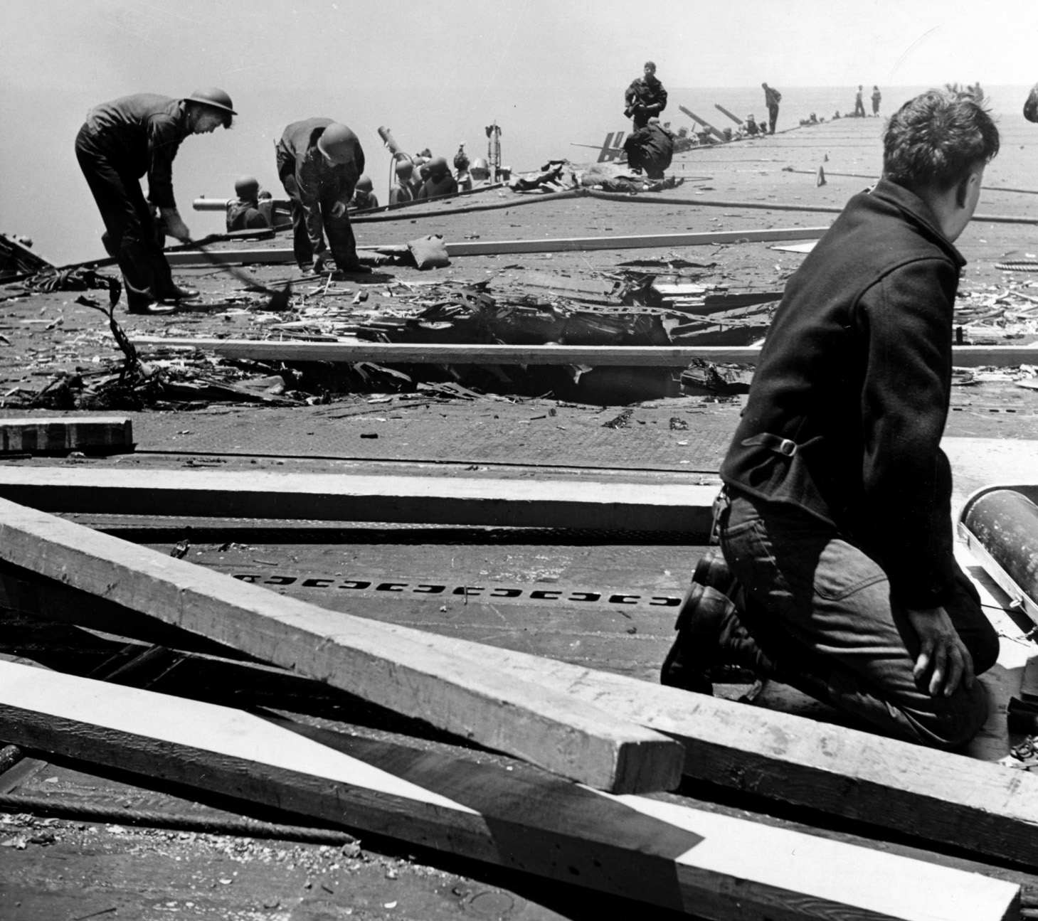 Sailors repair a sizable hole in the flight deck caused by an enemy bomb after the initial Japanese strike on the Yorktown. The bomb caused numerous casualties, while another temporarily caused the carrier to lose power. The deck was repaired, and flight operations resumed, but a second raid later in the day resulted in torpedo damage. As the battle neared its end, Yorktown was sunk after being torpedoed by a Japanese submarine.