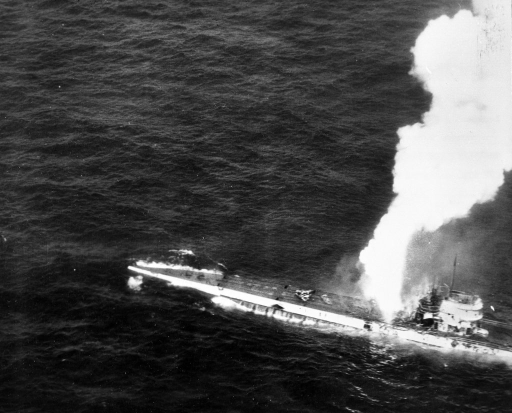 Fire erupts just aft of the conning tower of the German submarine U-515, under attack by the U.S. Navy hunter-killer group led by the escort carrier USS Guadalcanal.  U-515 went to the bottom of the Atlantic soon after this photograph was taken.