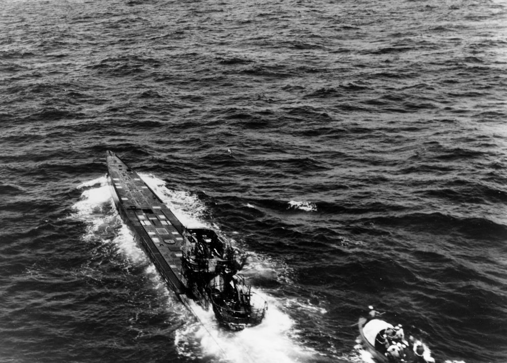 Despite the risk of U-505 being scuttled and blowing up, a boarding party from USS Pillsbury approaches the abandoned submarine, which is still underway. The Germans had intended to follow their abandonment doctrine and sink U-505 before it could be boarded.