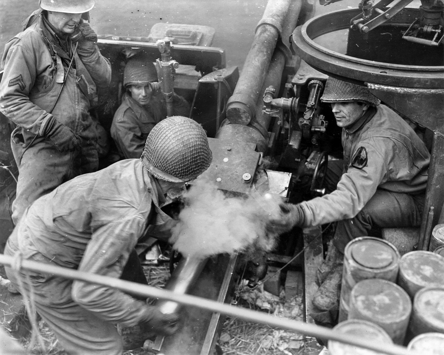 Men of the 9th Armored Division conduct a fire mission with their self-propelled 105mm gun, December 21, 1944. 