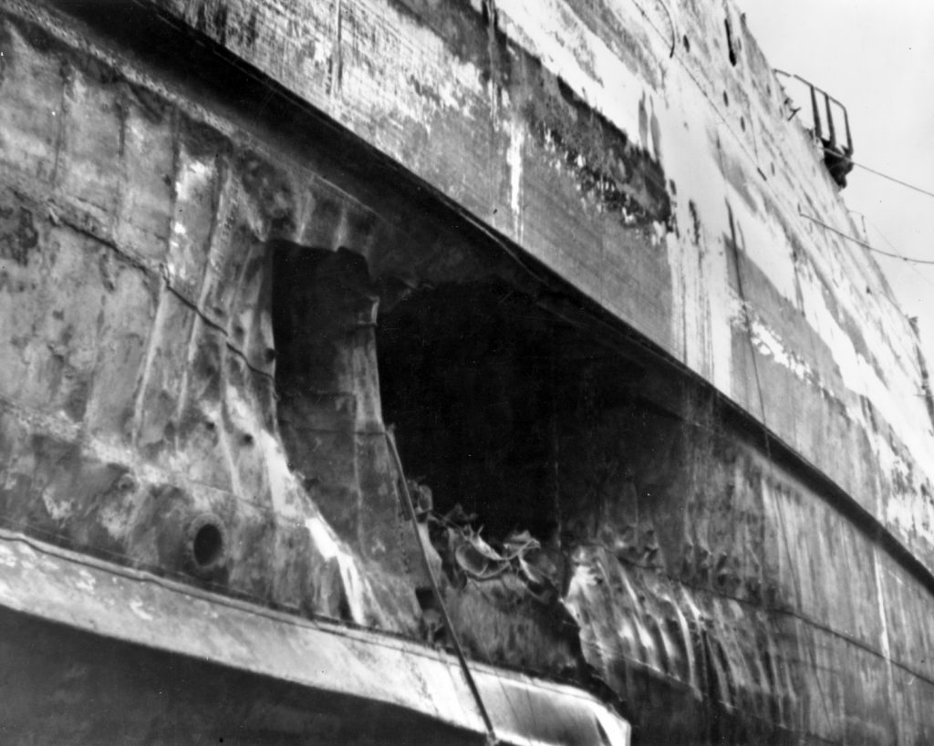 Torpedo damage to the hull of California, photographed at the Pearl Harbor Navy Yard in April 1942, after the ship had been dry-docked for repairs. Visible is the forward torpedo hole, showing the armor belt above the hole and bilge keel below it. 