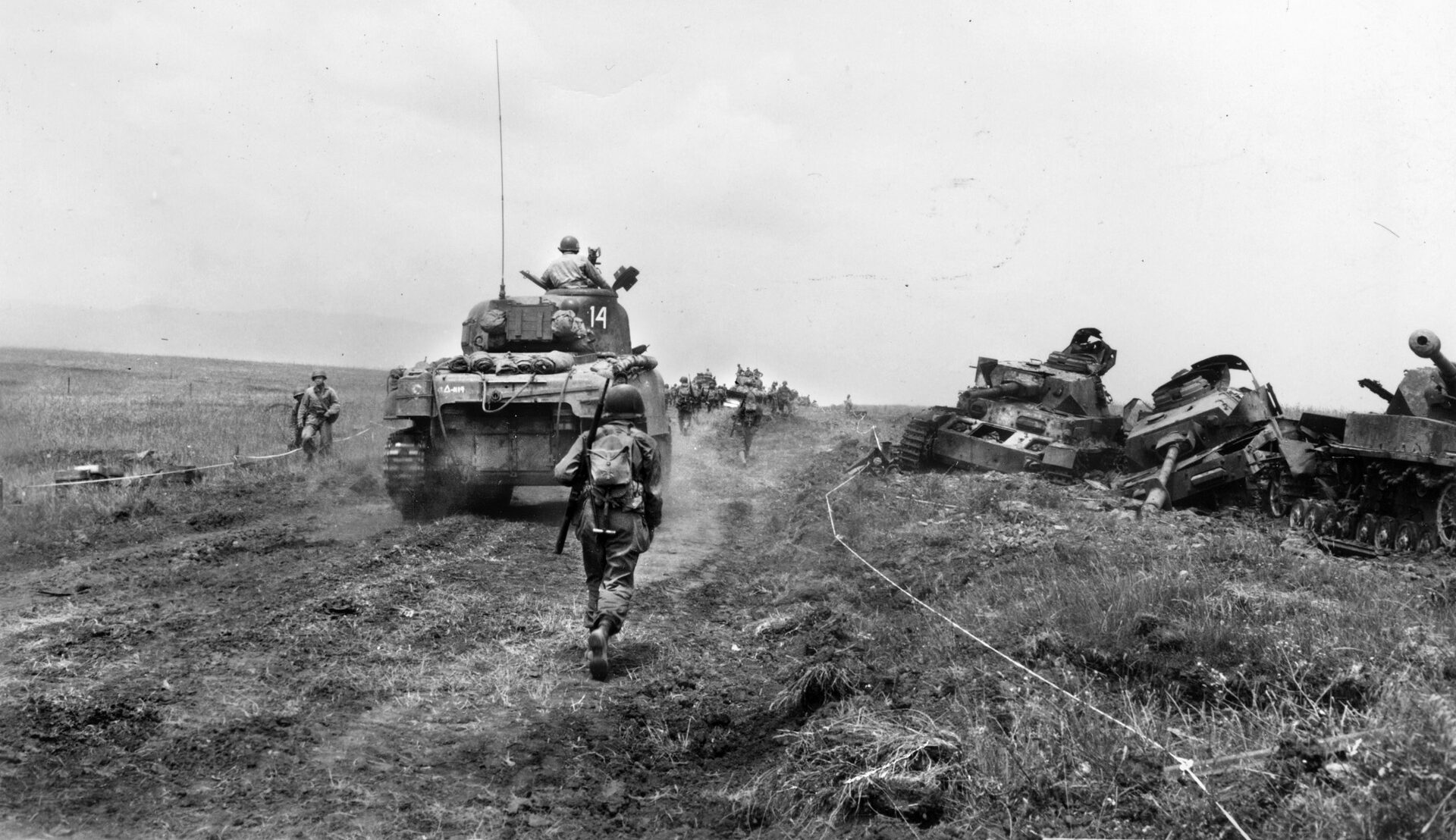 American tanks and troops press forward following white tape that marked  safe routes through enemy minefields.