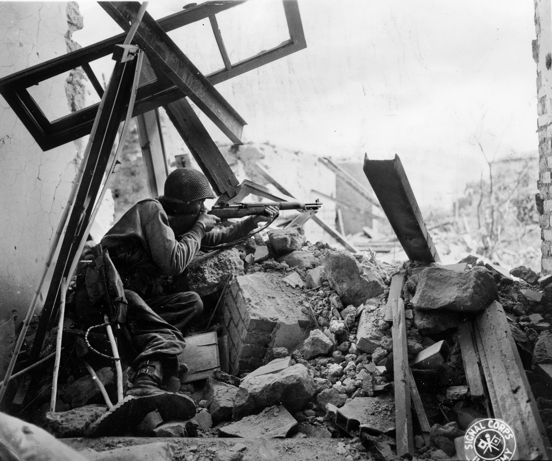 An American soldier fires from a concealed position in the ruins of Cisterna. The Germans inflicted dreadful casualties on the Americans in the see-saw fighting at Cisterna. 