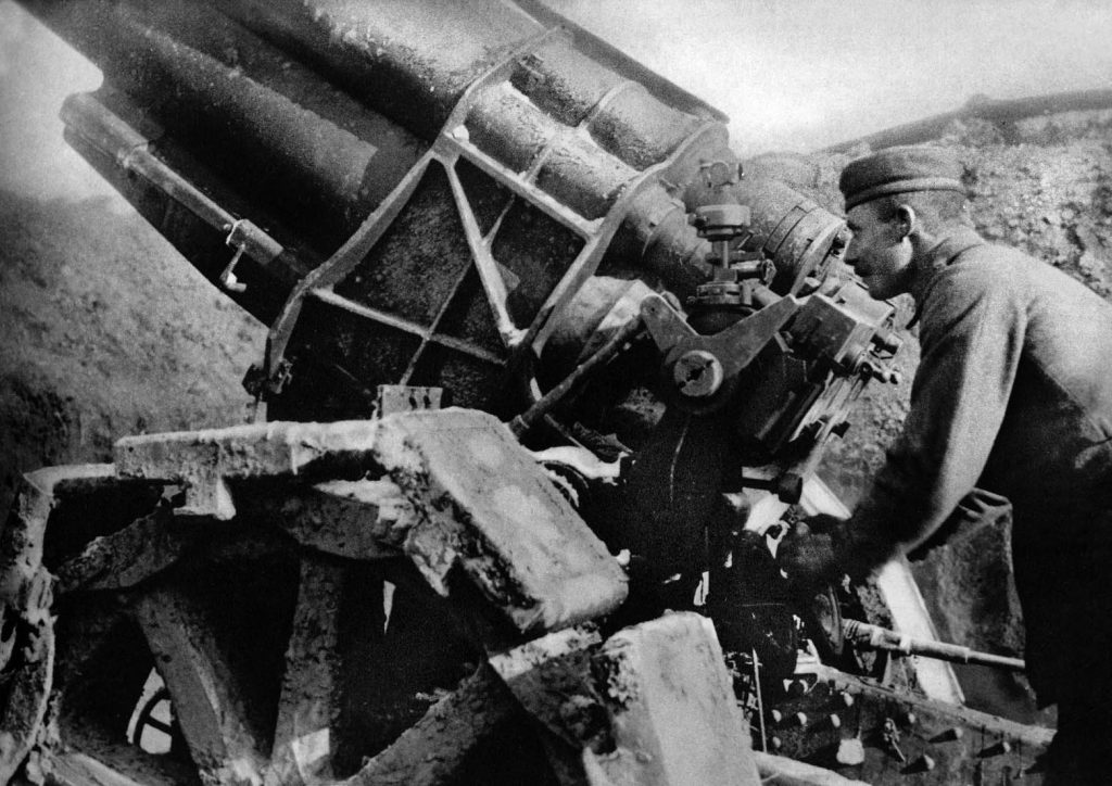 A German artilleryman prepares to fire a heavy artillery piece at the enemy. Direct hits by the big guns could collapse trench walls and sometimes even bunker roofs.