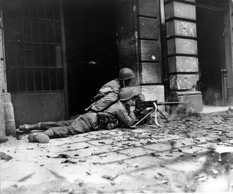 The best place to be in an urban battle was next to the buildings where it was possible to find a degree of cover from enemy fire. An American machine-gun team belonging to the 26th Infantry Regiment engages the enemy in mid-October.
