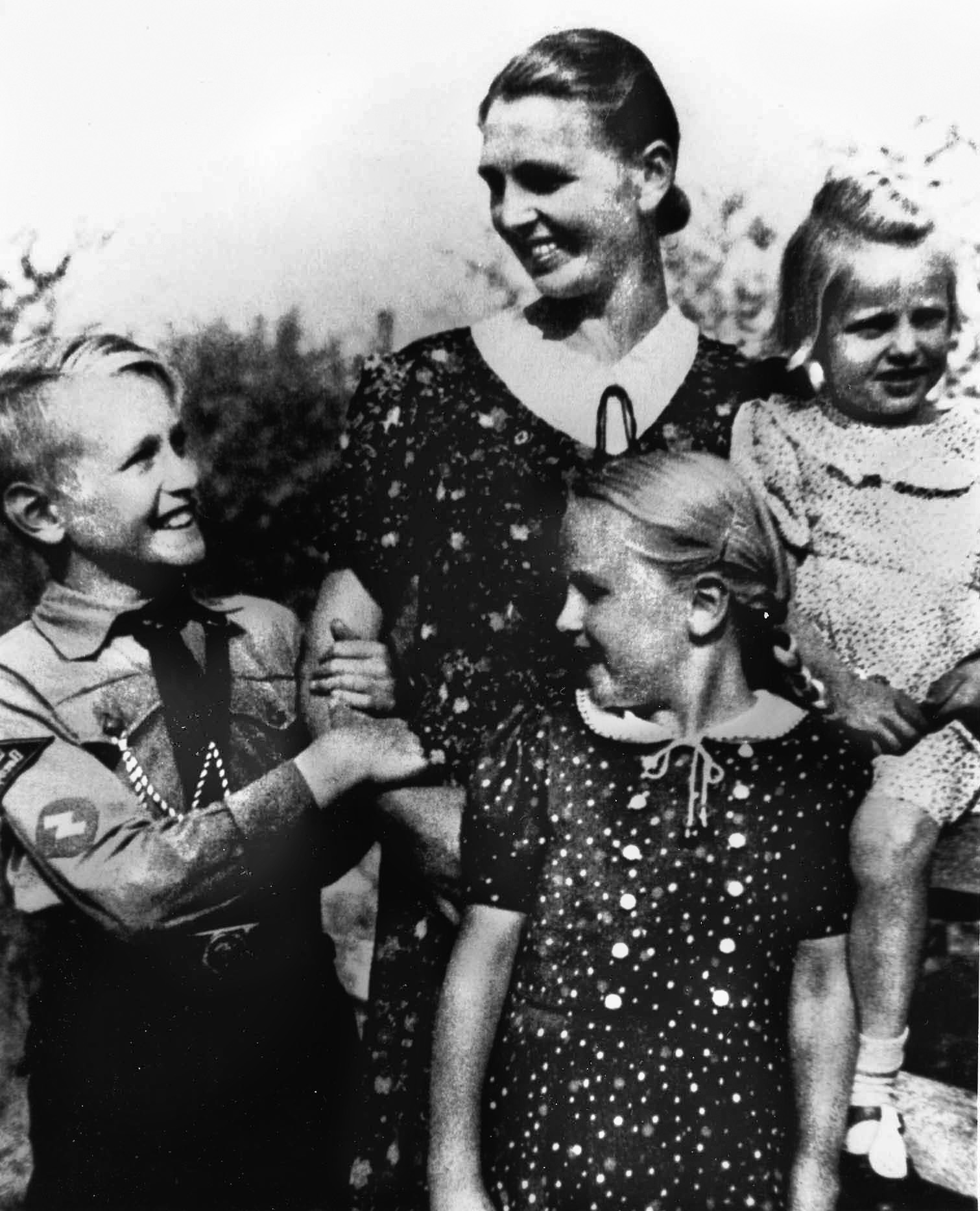 A German mother and her three children seem to be striking a pose as the ideal Nazi nuclear family, perhaps a product of the Lebensborn Program.