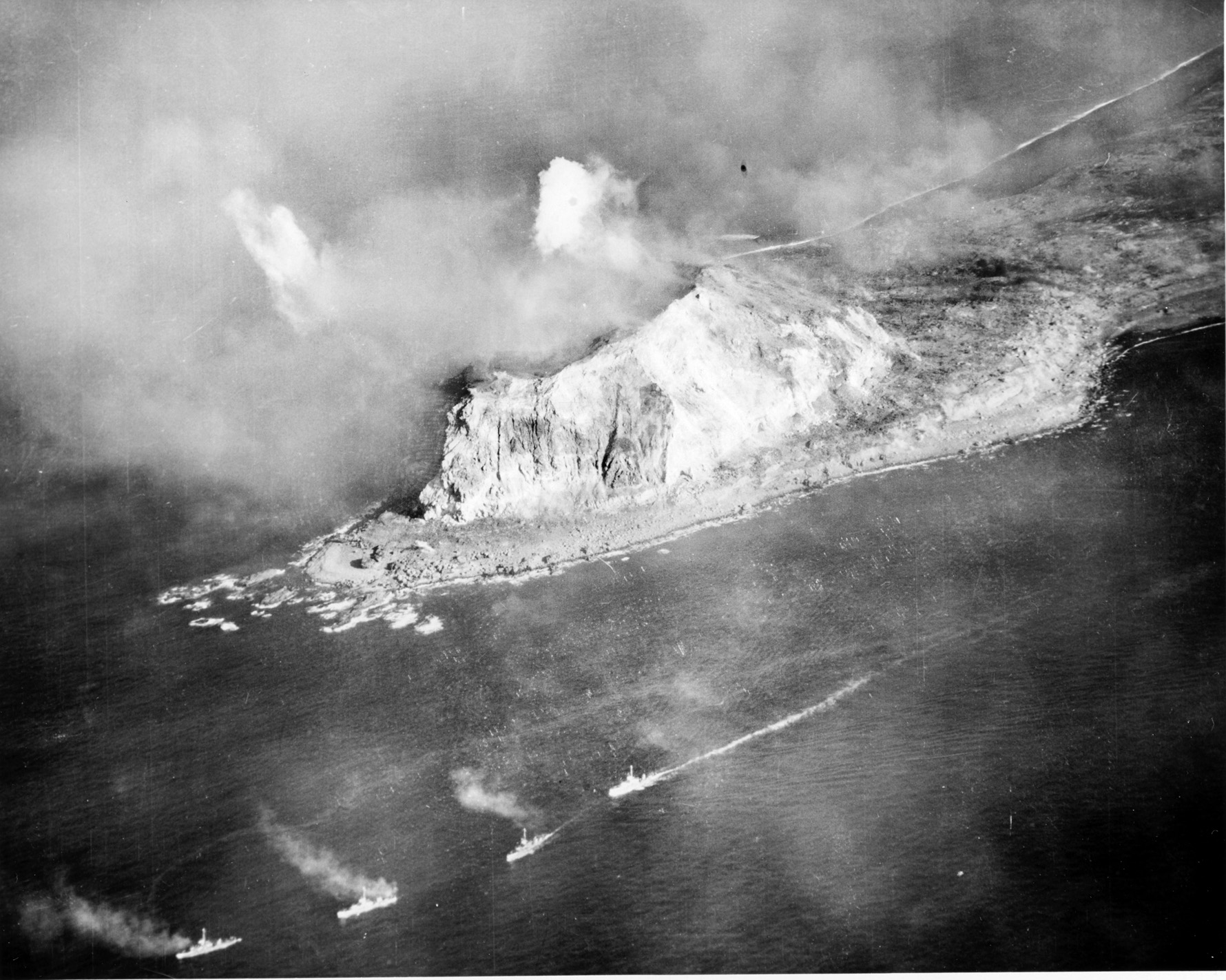 U.S. Navy ships steam past Mount Suribachi on the southern tip of the island during the naval bombardment that preceded the landing. The Japanese had honeycombed the extinct volcano with artillery positions, machine-gun nests, and tunnels. 