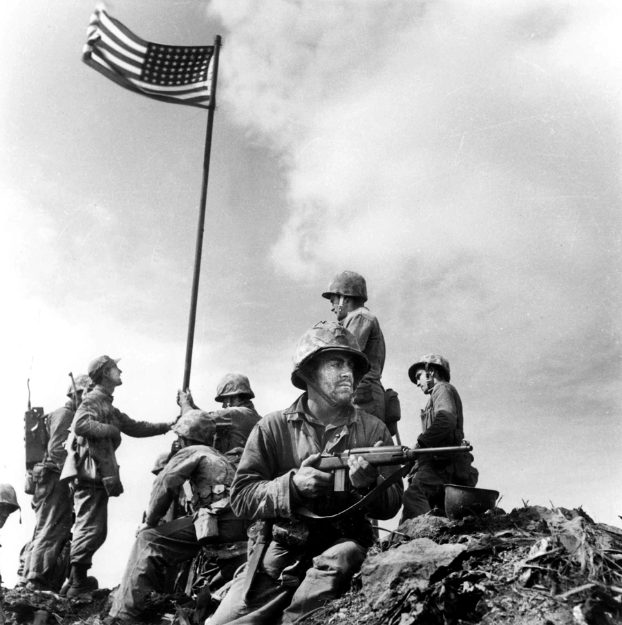 Marines of Company E of the 2nd Battalion, 28th Marines, raise the first U.S. flag atop Mount Suribachi on February 23. The flag was taken from the USS Missoula, a tank-transport ship. 