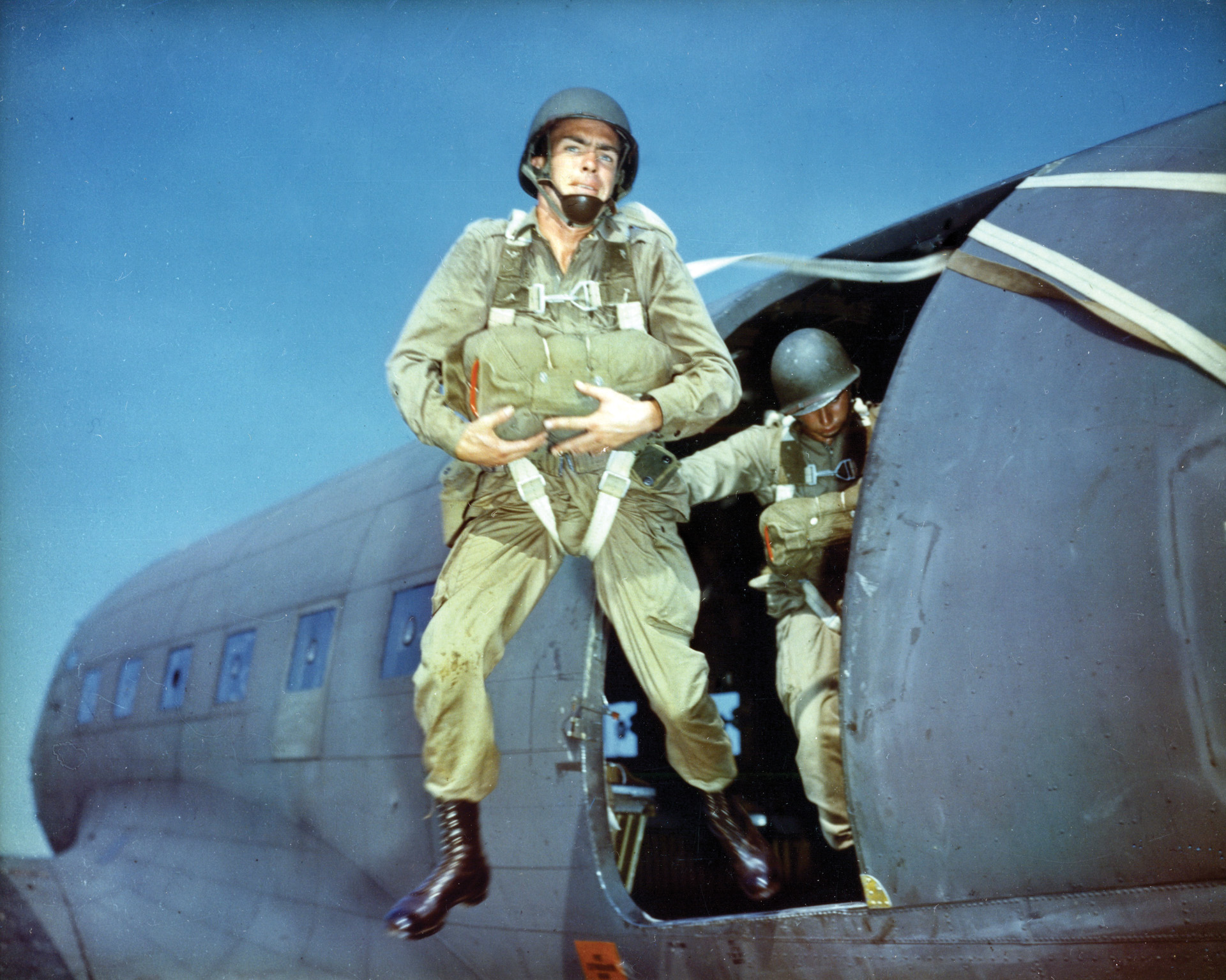 During a wartime training exercise, an American paratrooper exits a transport plane. Casualties among the airborne troops were expected to be high on D-Day, but despite difficulties turned out to be acceptable.