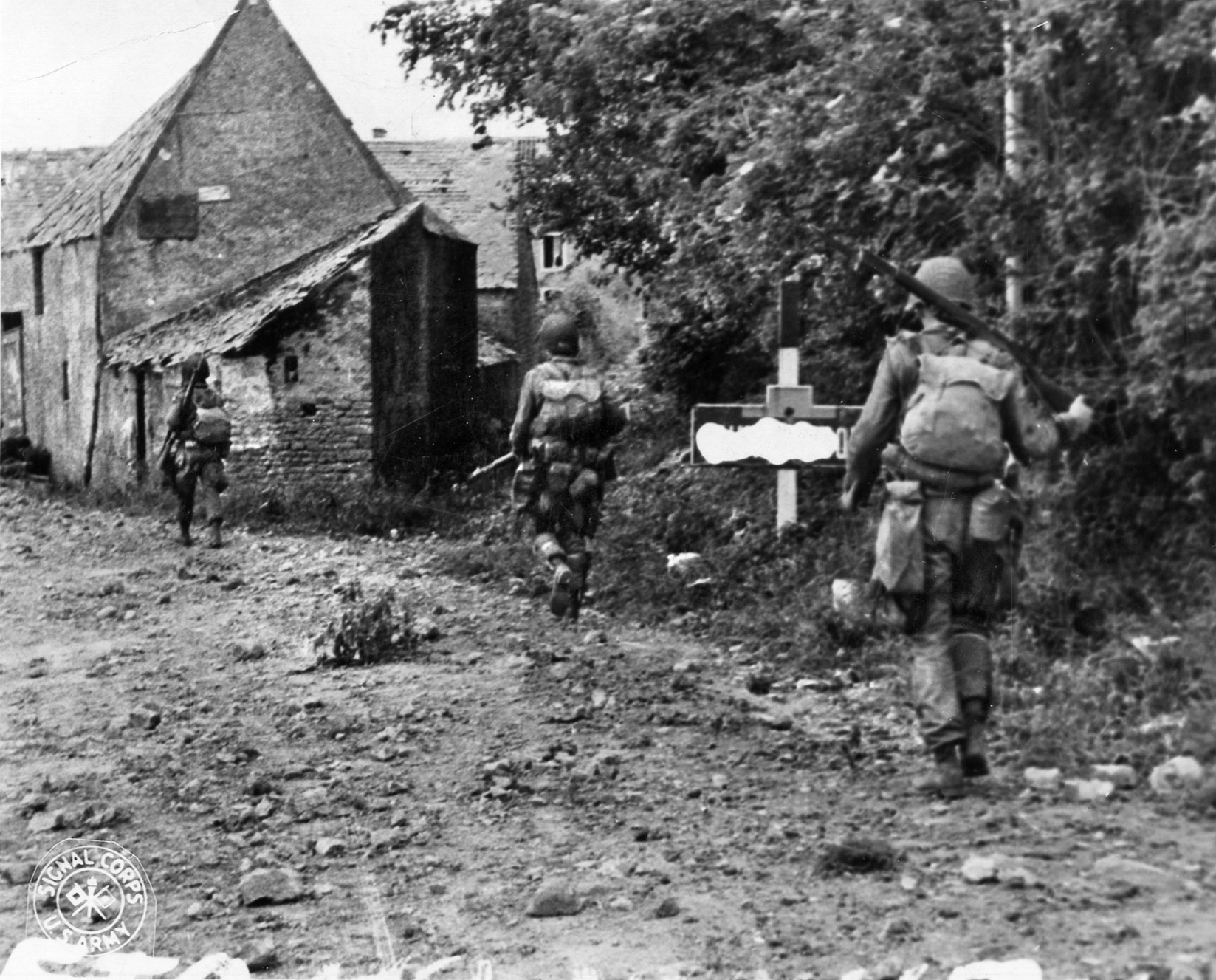 A short time after parachuting into Normandy during the predawn hours of June 6, 1944, American paratroopers advance warily down a dirt road and into a small village. Contact with the Germans was, in some cases, immediate upon landing. 
