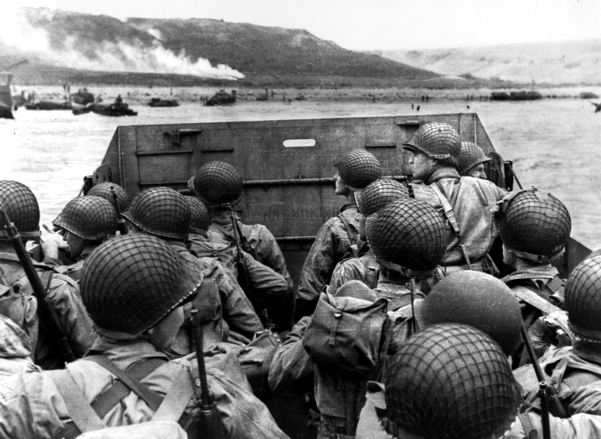 Men of the 16th Infantry Regiment peer over the sides of their LCVP toward smoky Omaha Beach and nervously await the moment when the ramp will drop and they will wade into hell. 