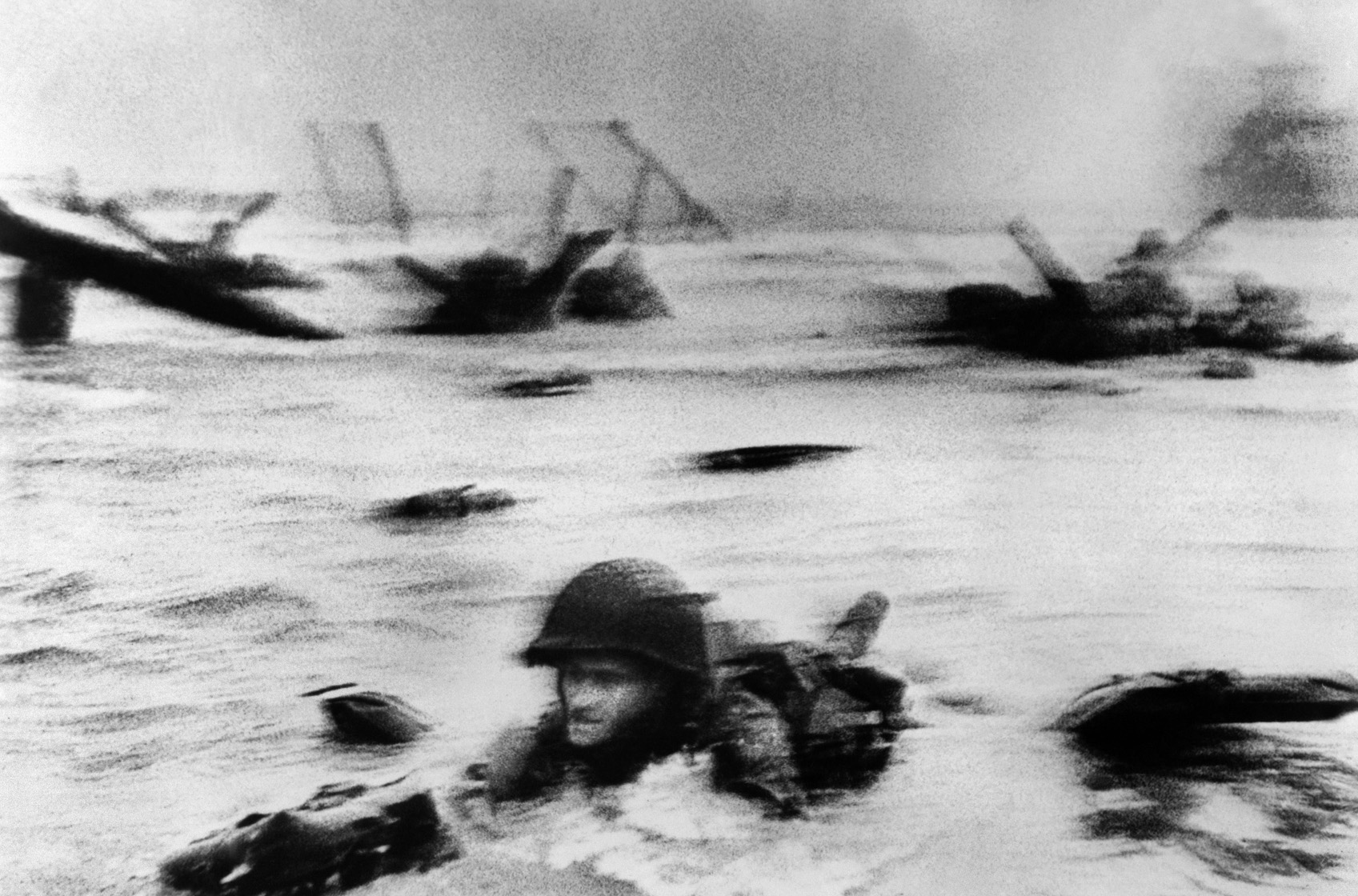 Having made it to the water’s edge, Capa turned and snapped this photo of a GI crawling behind him through the surf, hoping to find a place of safety. The soldier has been identified as either Huston Riley or Edeward Regan. 