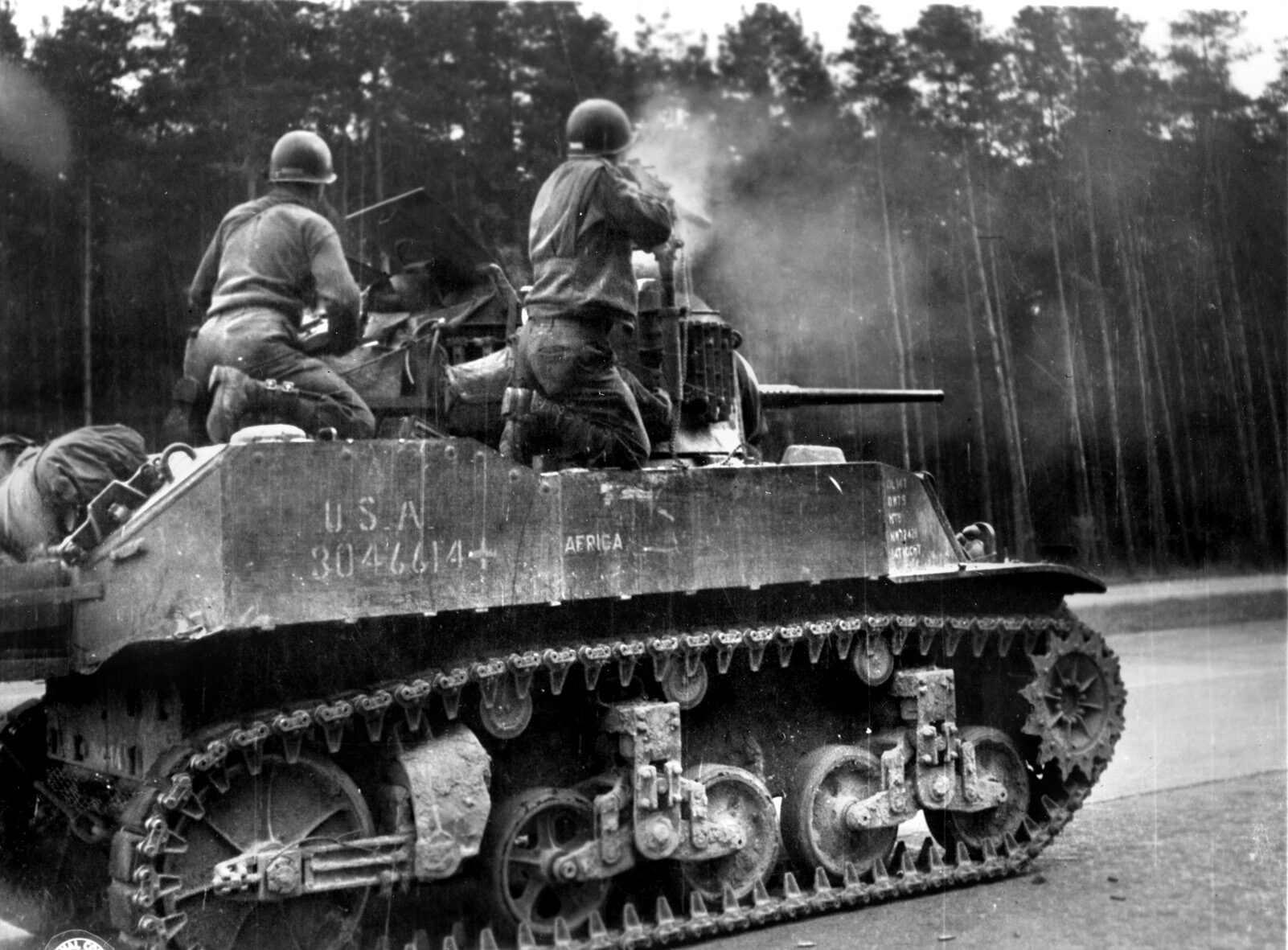 The crew of a Stuart tank fires on snipers in the woods near Dessau, Germany.