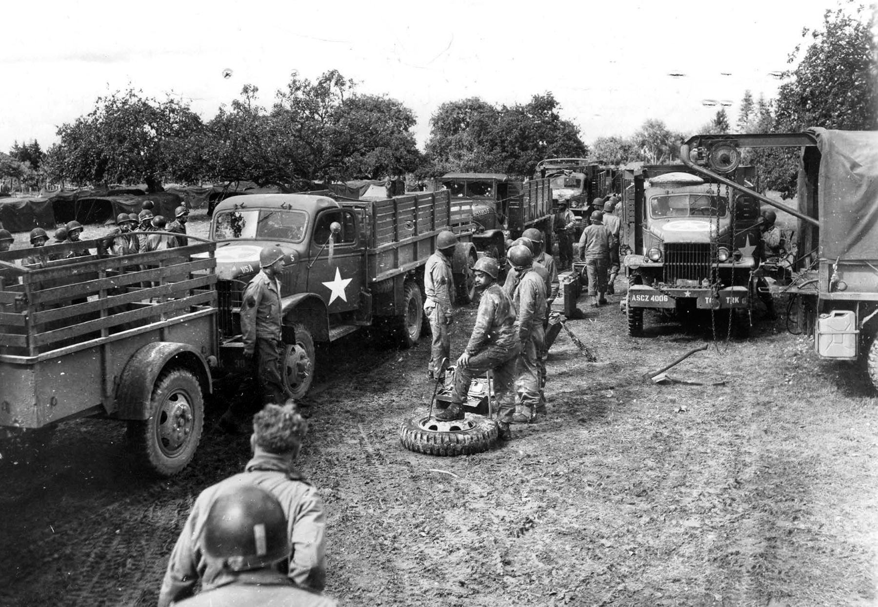  A convoy makes a refueling stop and  a change of drivers at a makeshift service station near St. Denis, France, September 7, 1944.