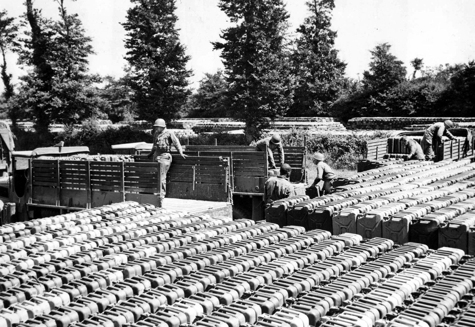 Trucks from different units draw cans of gasoline from a quartermaster depot “somewhere in France.” After the five-gallon “jerrycans” were empty, they were refueled from tankers on the beachheads and returned to quartermaster depots. 