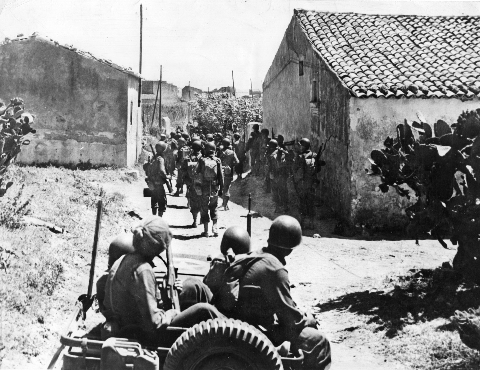 Members of the U.S. 45th Infantry Division march into the town of Scoglitti on their way to the northern coast.