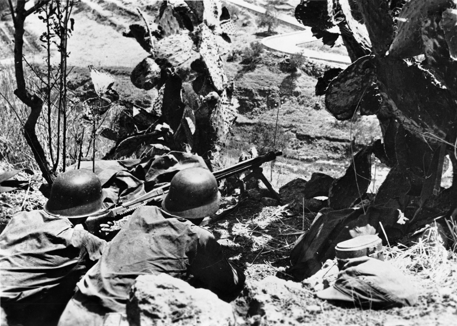Using cacti to conceal their position on Bloody Ridge (Hill 335), German machine gunners prepare to slow the American drive across the island’s northern coast. 