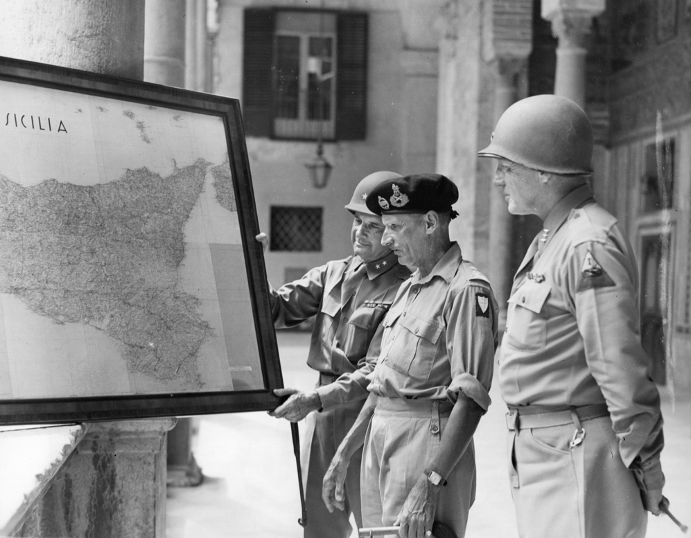 Generals Keyes, Montgomery, and Patton study a large situation map of Sicily to plot their next moves. 