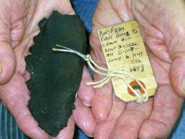Two wartime souvenirs: a piece of German shrapnel that pierced his tent while on a layover at Poltava and the tag and cotter pin from the first bomb his B-17 dropped over Normandy on D-Day, June 6, 1944.