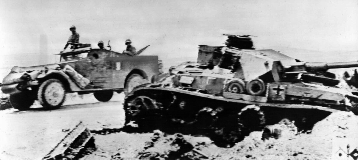 An Allied armored car races past the hulk of a German Mark IV panzer destroyed in earlier fighting. Losses in armor, both Allied and Axis, were tremendous during the desert war.