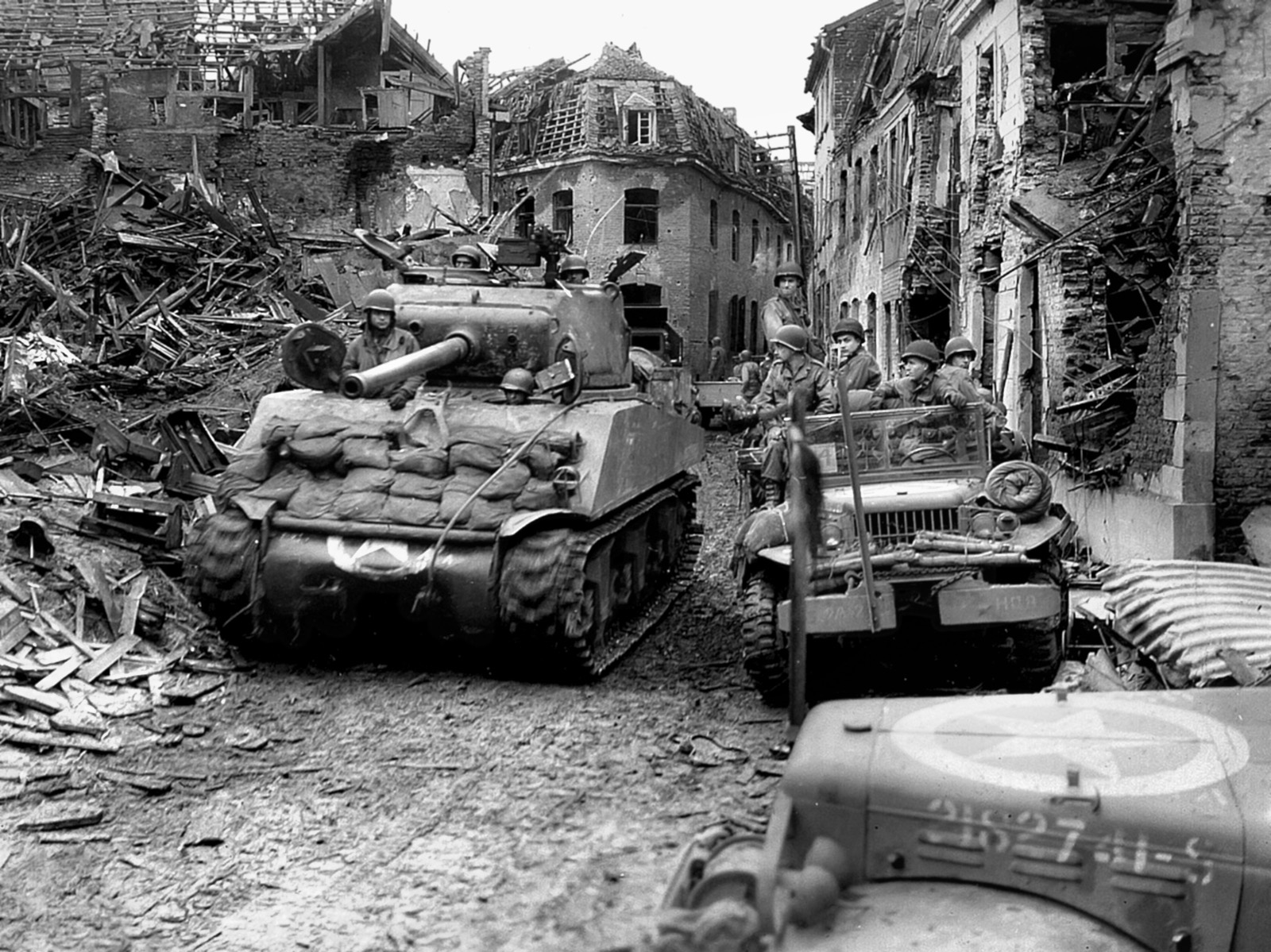 An M4A3 Sherman tank from the 771st Tank Battalion, supporting the 84th Infantry Division, moves through the rubble-strewn streets of Linnich, Germany, February 24, 1945. 