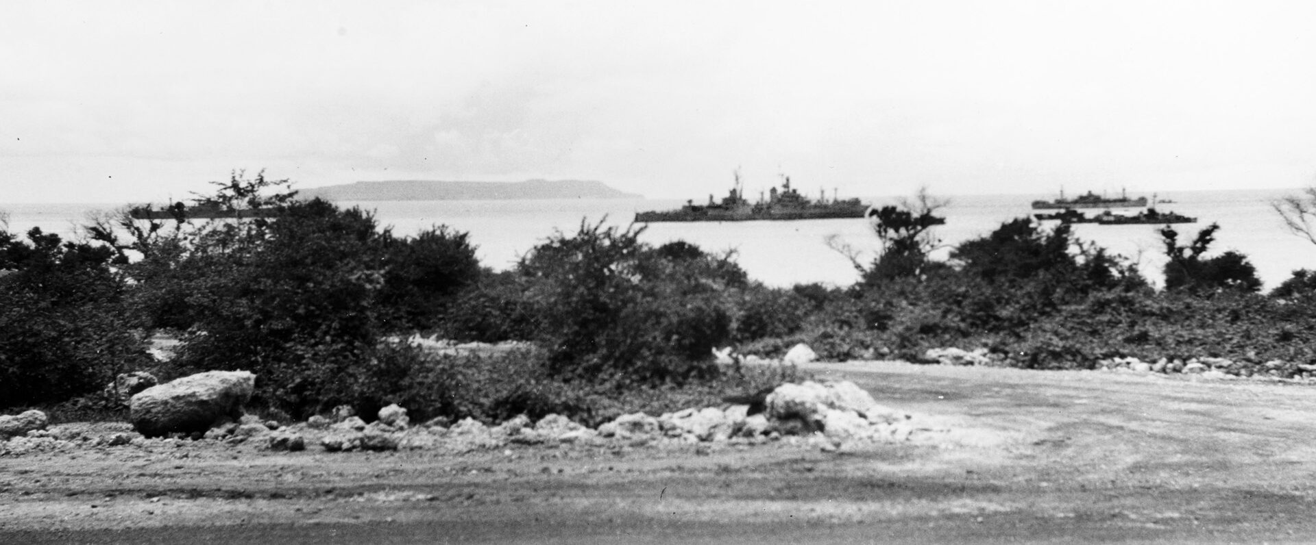 After delivering her cargo of secret components to Tinian Island for the atomic bomb that would be used on Hiroshima, the Indianapolis (center) departs for her trip to Guam—a voyage that was never completed.