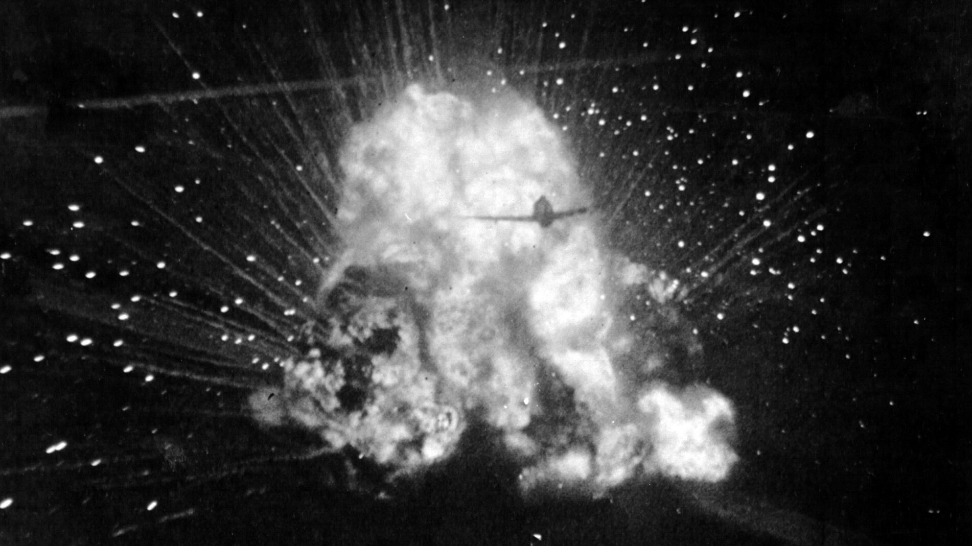 A P-47 is silhouetted against an exploding German ammunition truck. The P-47s were outstanding in the ground-support role. 