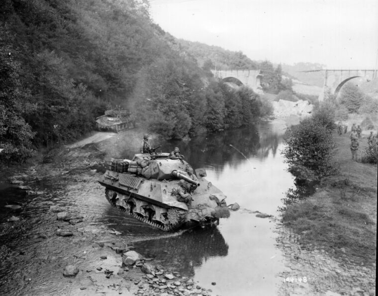 Constructed on the platform of the M4 Sherman tank, the M10 “Wolverine” tank destroyer sported a 76mm high-velocity gun that had better armor-piercing capability than the Sherman’s standard 75mm gun, but a fatal flaw was the slow, hand-cranked turret. Here an M10 crosses a stream somewhere on the Belgium-German border, March 1945.