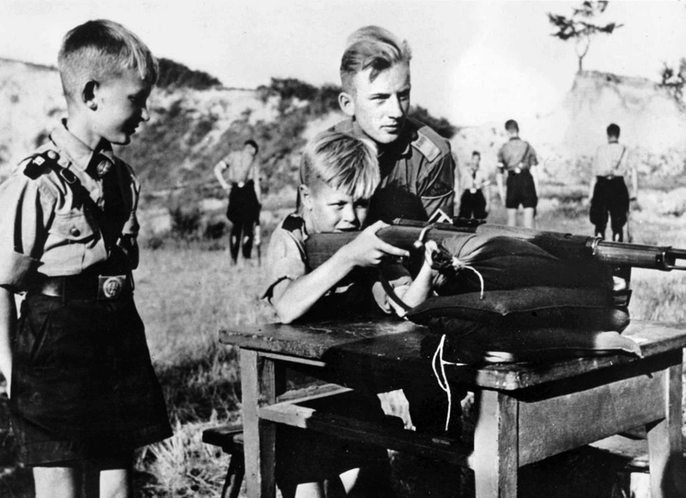 Eleven-year-old boys receive instruction on target shooting as part of Hitler Youth activities. Vogel credits being selected to join a flak crew with being a good shot with a .22 rifle. 