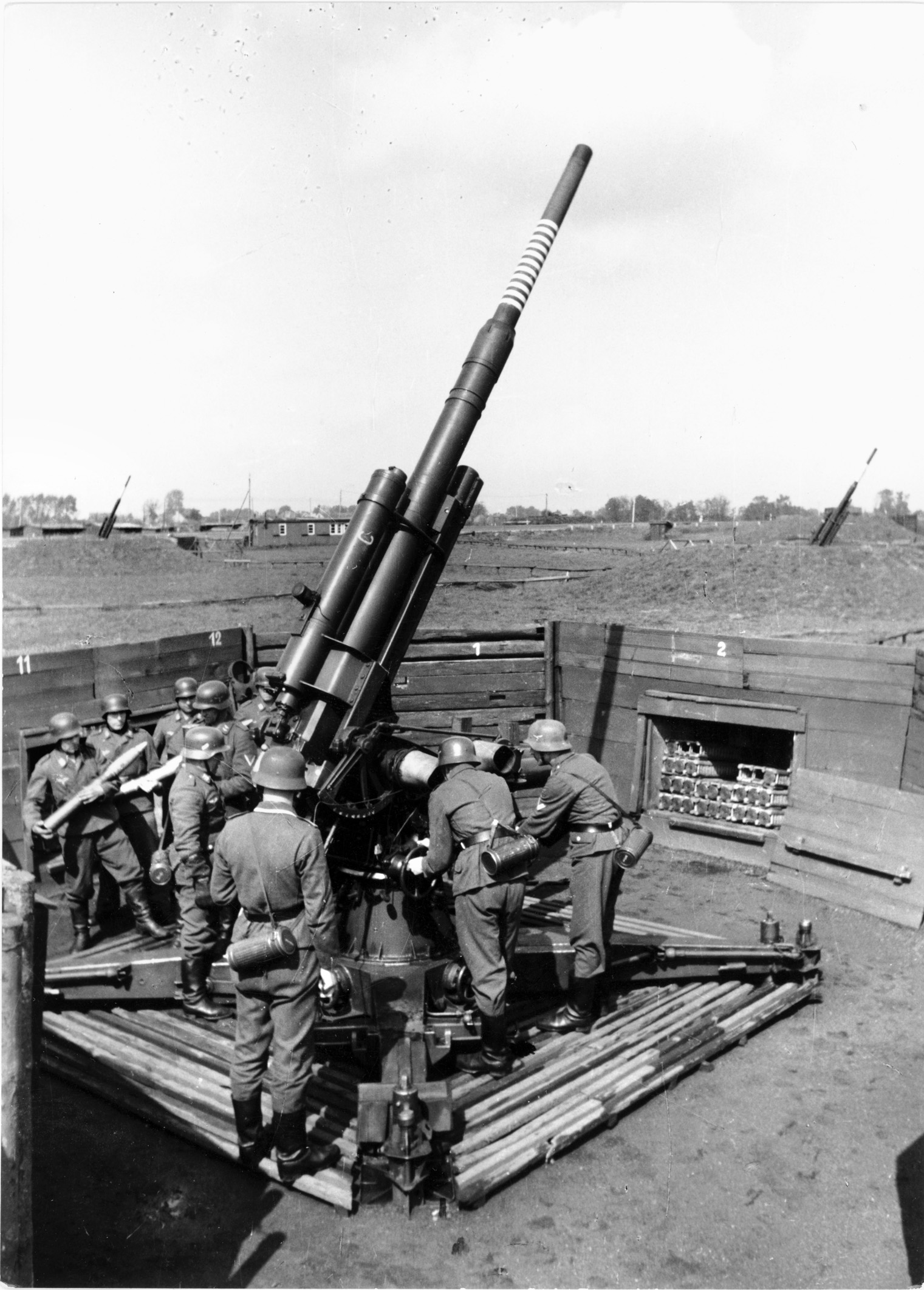 In a field bristling with anti-aircraft weapons, a German gun crew practices loading an 88mm gun. As the war went badly for Germany and air raids became more frequent, experienced gunners such as Gunther became more in demand.