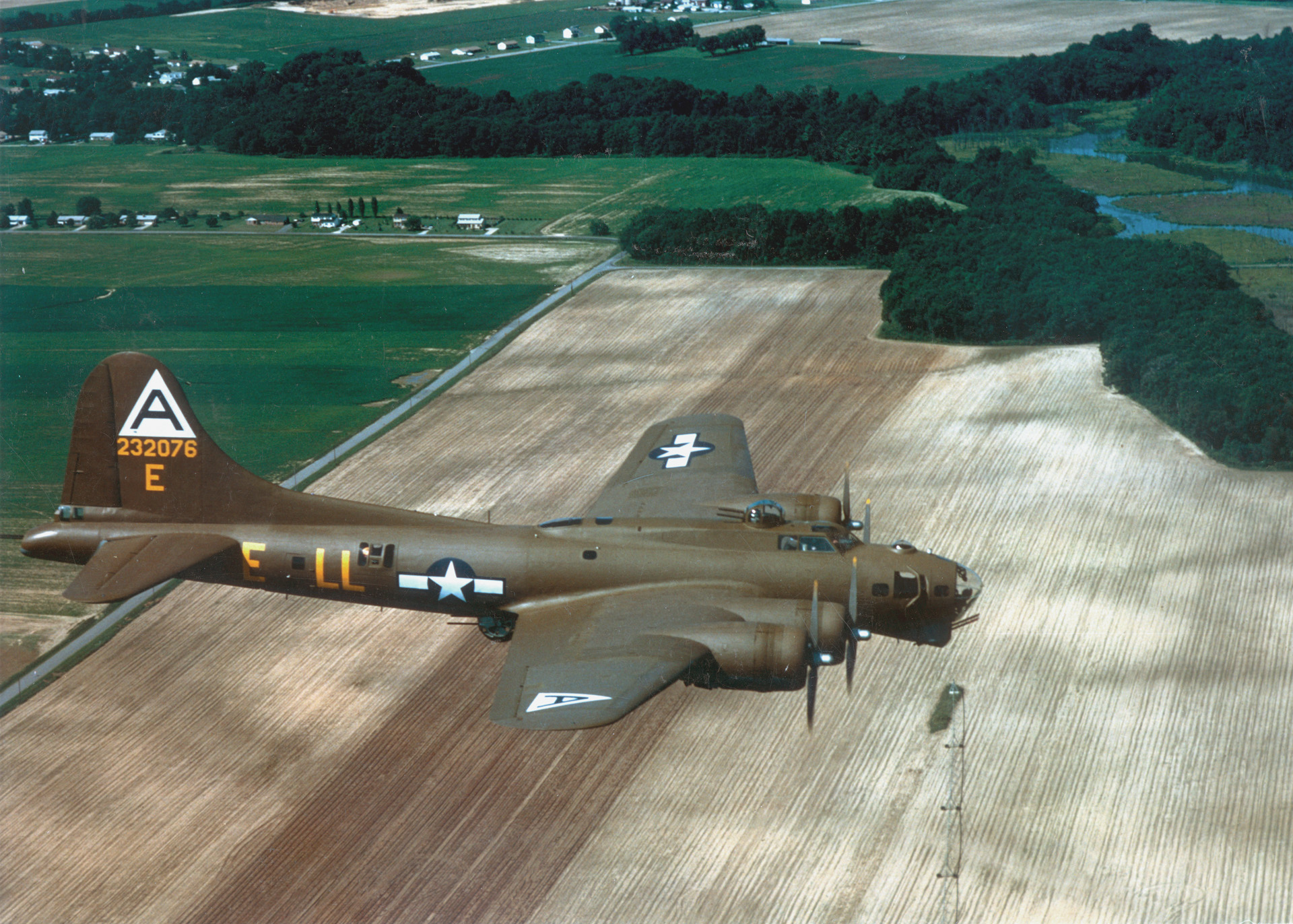 An olive-drab B-17G Flying Fortress of the 401st Bomb Squadron, 91st Bomb Group, flies over the English countryside on its way to hit targets in Germany. Later in the war, the bombers were left unpainted to save weight. The Eighth U.S. Air Force lost over 10,500 planes and 47,000 personnel killed and wounded in combat during the war. 