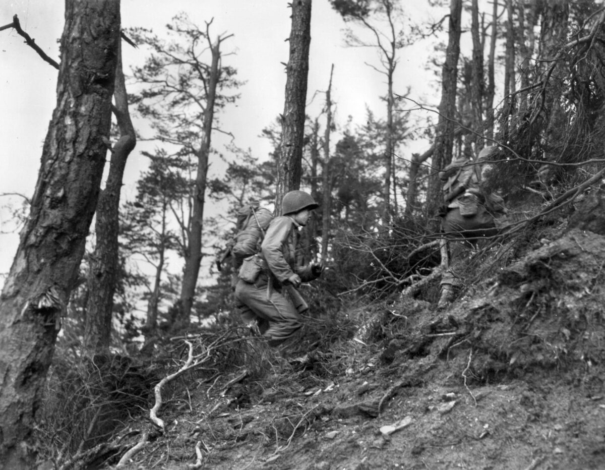 Japanese American soldiers of the 100th Infantry Battalion/442nd Regimental Combat Team climb a forested hill in the rugged Vosges Mountains region of northeast France, October 1944. The “Nisei” troops proved their loyalty and worth in combat despite being  discriminated against back home. 