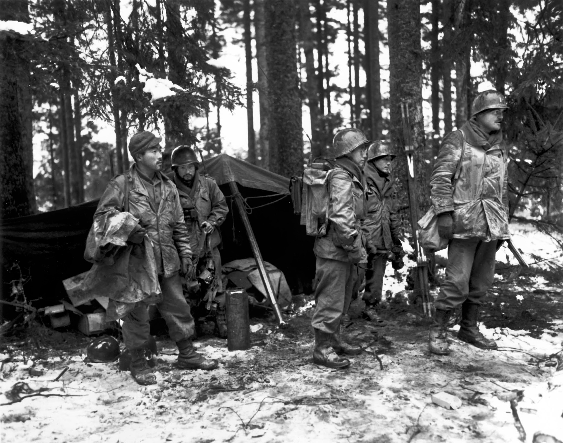 With snow covering the ground in the Vosges region, Bob Yorita, Shigeru Suekuni, Lefty Ichihara, Michio Takata, and Captain Joe Hill of Company F, 2nd Battalion, 442nd RCT, prepare to move to a new command post, November 14, 1944. 