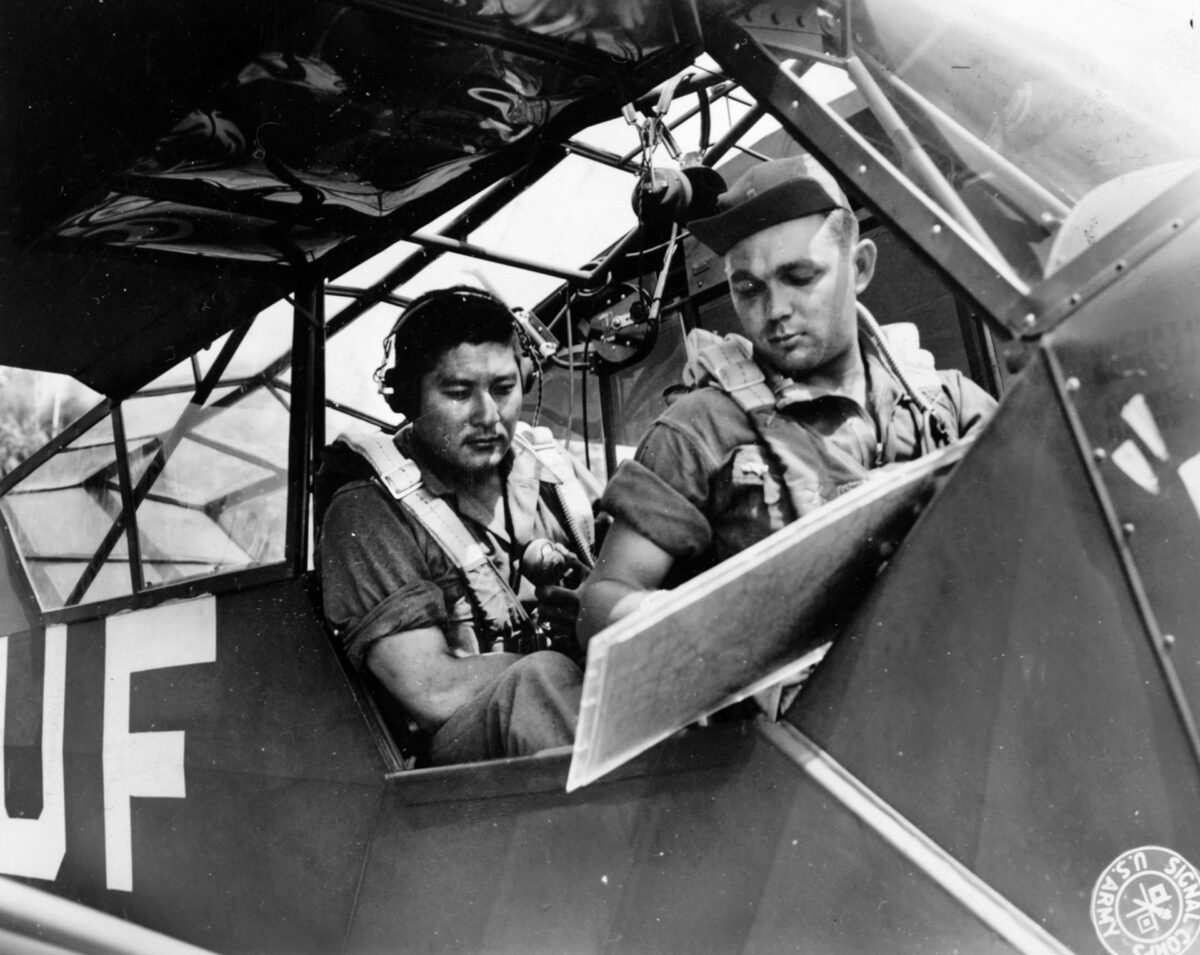 Artillery observer Sergeant Arata Kimura (left) of the 442nd confers with pilot Lieutenant Joseph Polancil before taking off in a spotter plane east of Livorno, Italy, July 1944. 